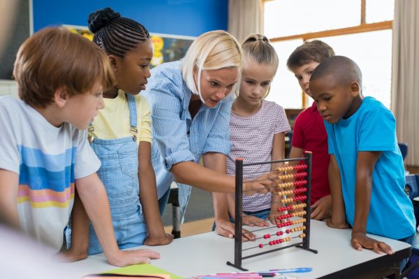 Teacher showing abacus to children